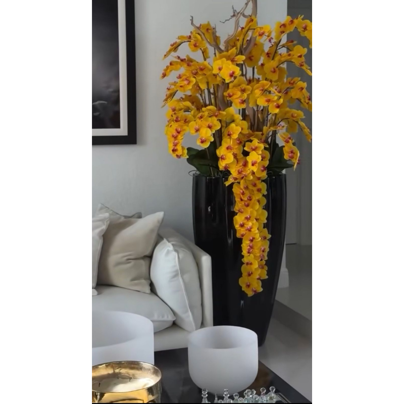 Hängende gelbe Orchideen in glänzend schwarzer San Jose Vase