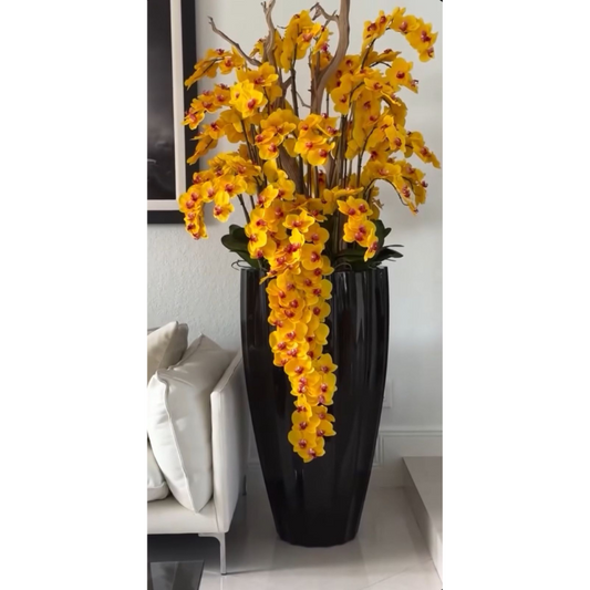 Hängende gelbe Orchideen in glänzend schwarzer San Jose Vase